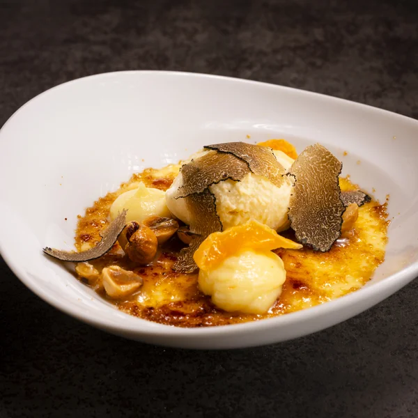 Dessert mit Trüffeln, Nüssen und Vanillecreme in weißer Schale