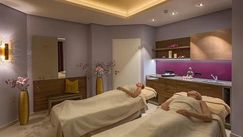 Zwei Personen entspannen sich auf Massageliegen im ruhigen Spa-Raum