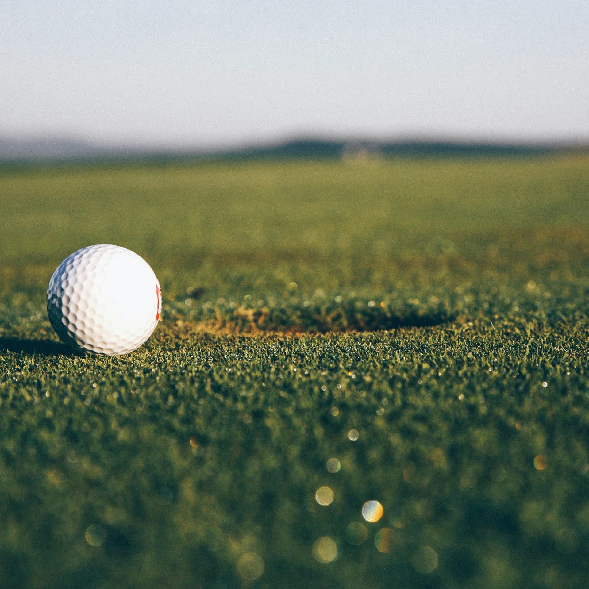 Nahaufnahme eines Golfballs auf dem Rasen mit verschwommenem Hintergrund