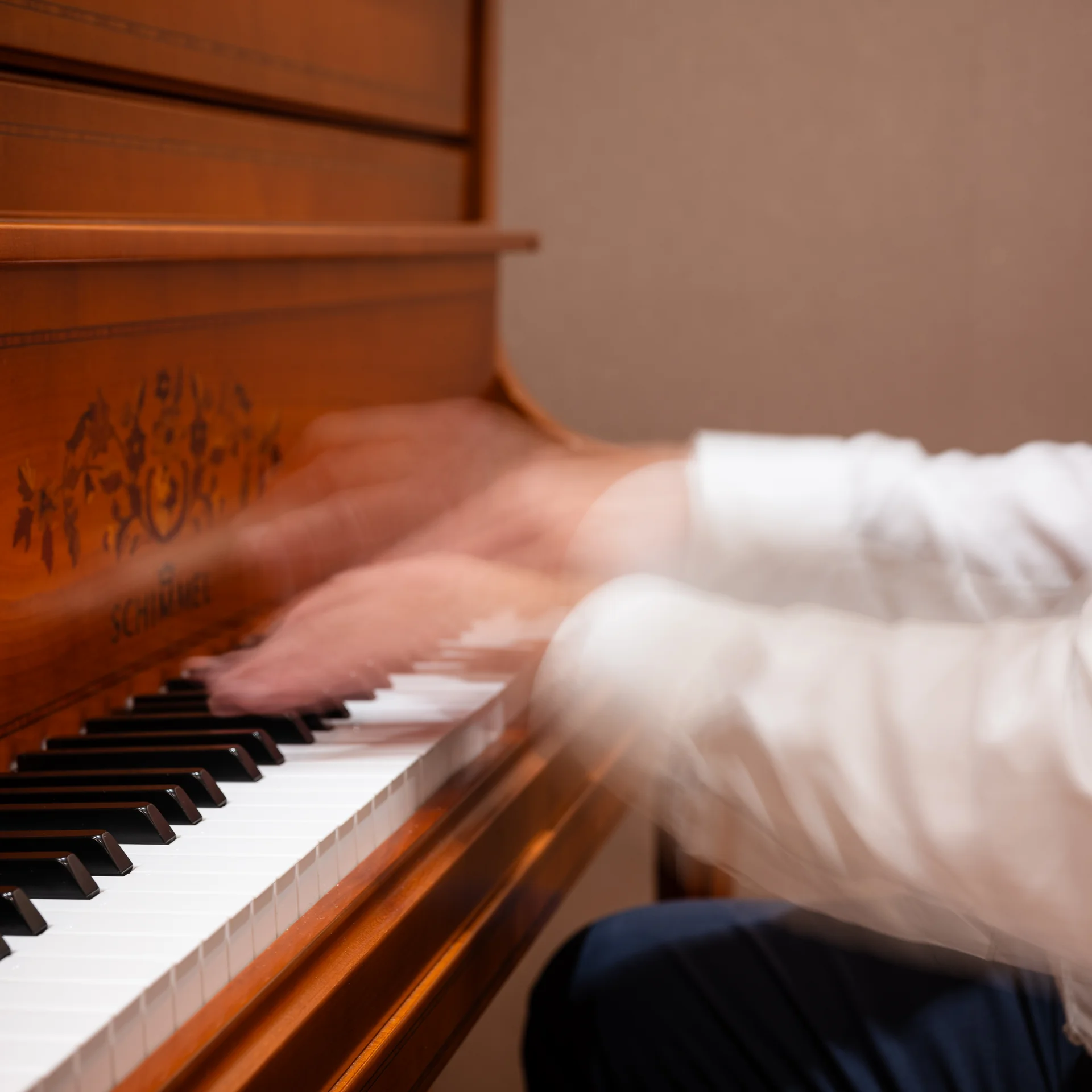 Mann spielt Klavier mit schnellen Handbewegungen