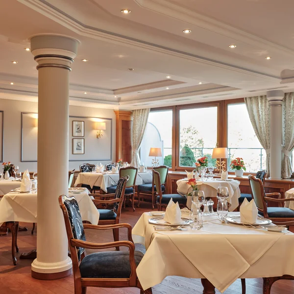 Elegantes Restaurant mit gedeckten Tischen und stilvollen Stühlen