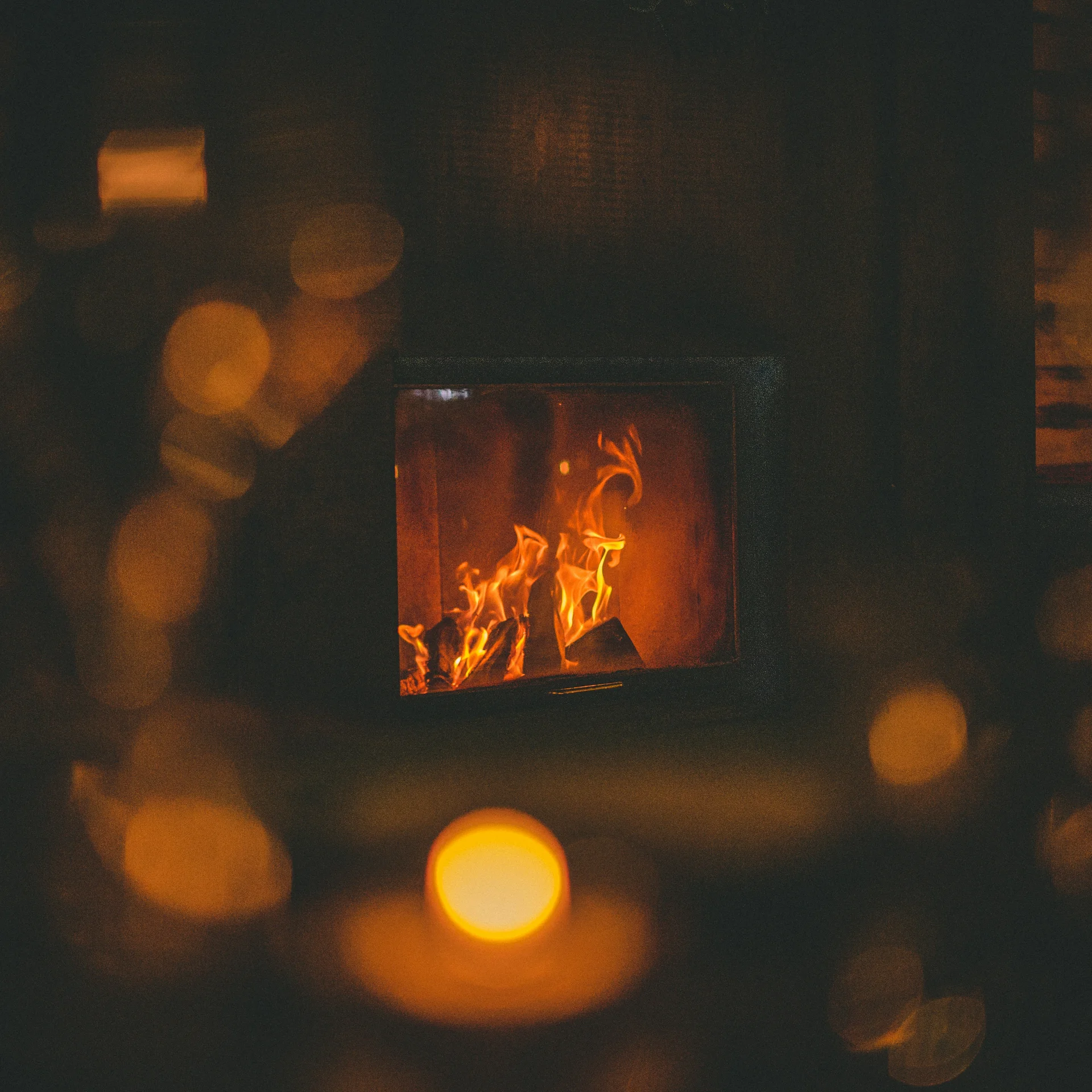 Fire burning in a fireplace in a dark, cozy room