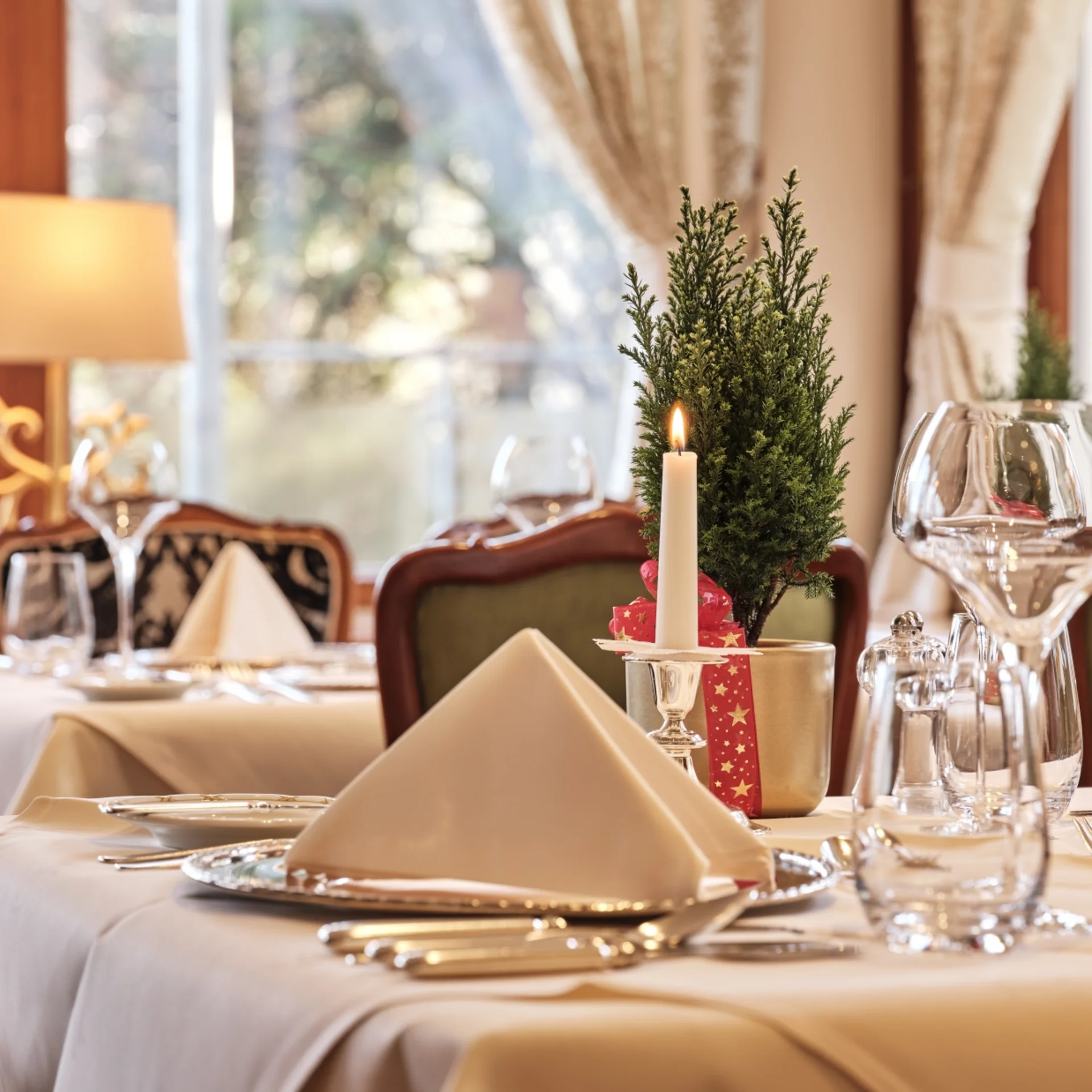 Festlich gedeckter Tisch mit Kerze und Weihnachtsdekoration in elegantem Restaurant