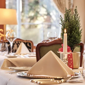 Festlich gedeckter Tisch mit Kerze und Weihnachtsdekoration in elegantem Restaurant