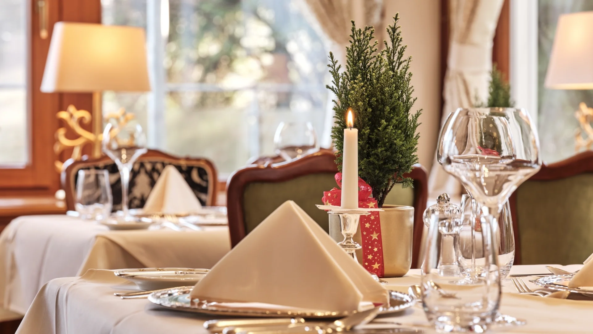 Festlich gedeckter Tisch mit Kerze und Weihnachtsdekoration in elegantem Restaurant
