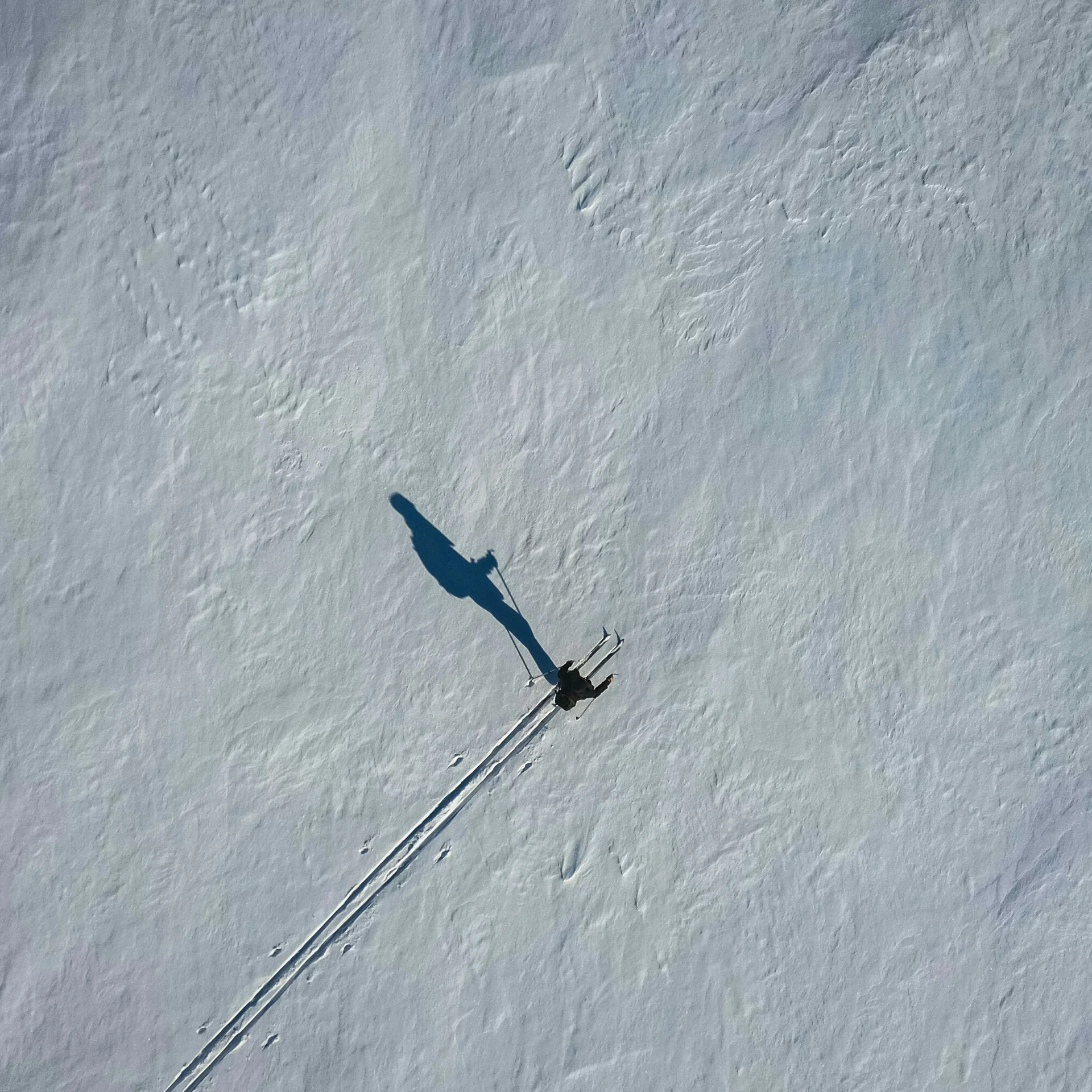 Skifahrer zieht Spuren durch weiten schneebedeckten Hang