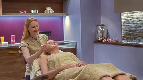 Frau erhält Gesichtsbehandlung in einem Spa mit entspannter Atmosphäre