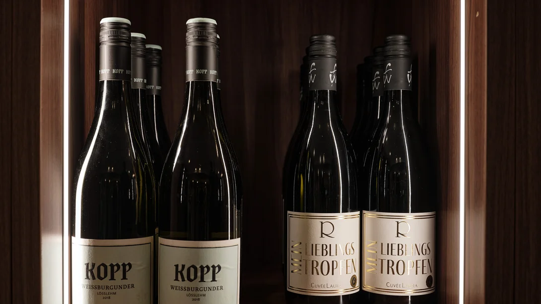 Séjour à Hinterzarten | L’art de vivre au ralenti à l’hôtel Reppert Bouteilles de vin sur une étagère en bois éclairée