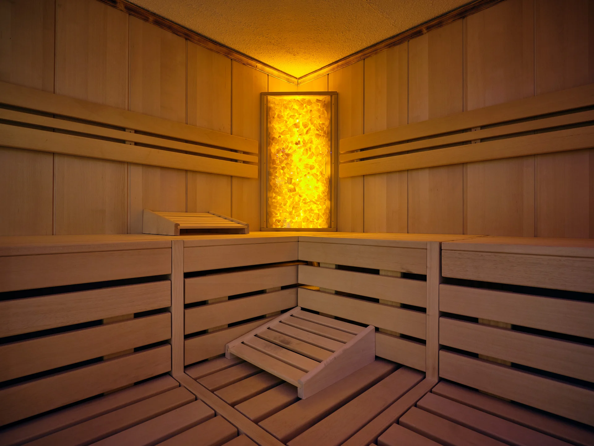 Innenraum einer Sauna mit Holzverkleidung und warmem Licht