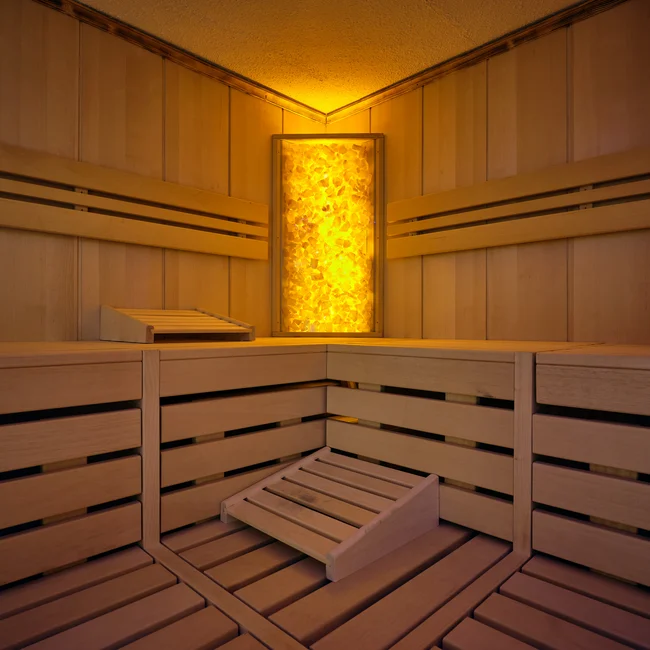 Interior of a sauna with wooden paneling and warm lighting
