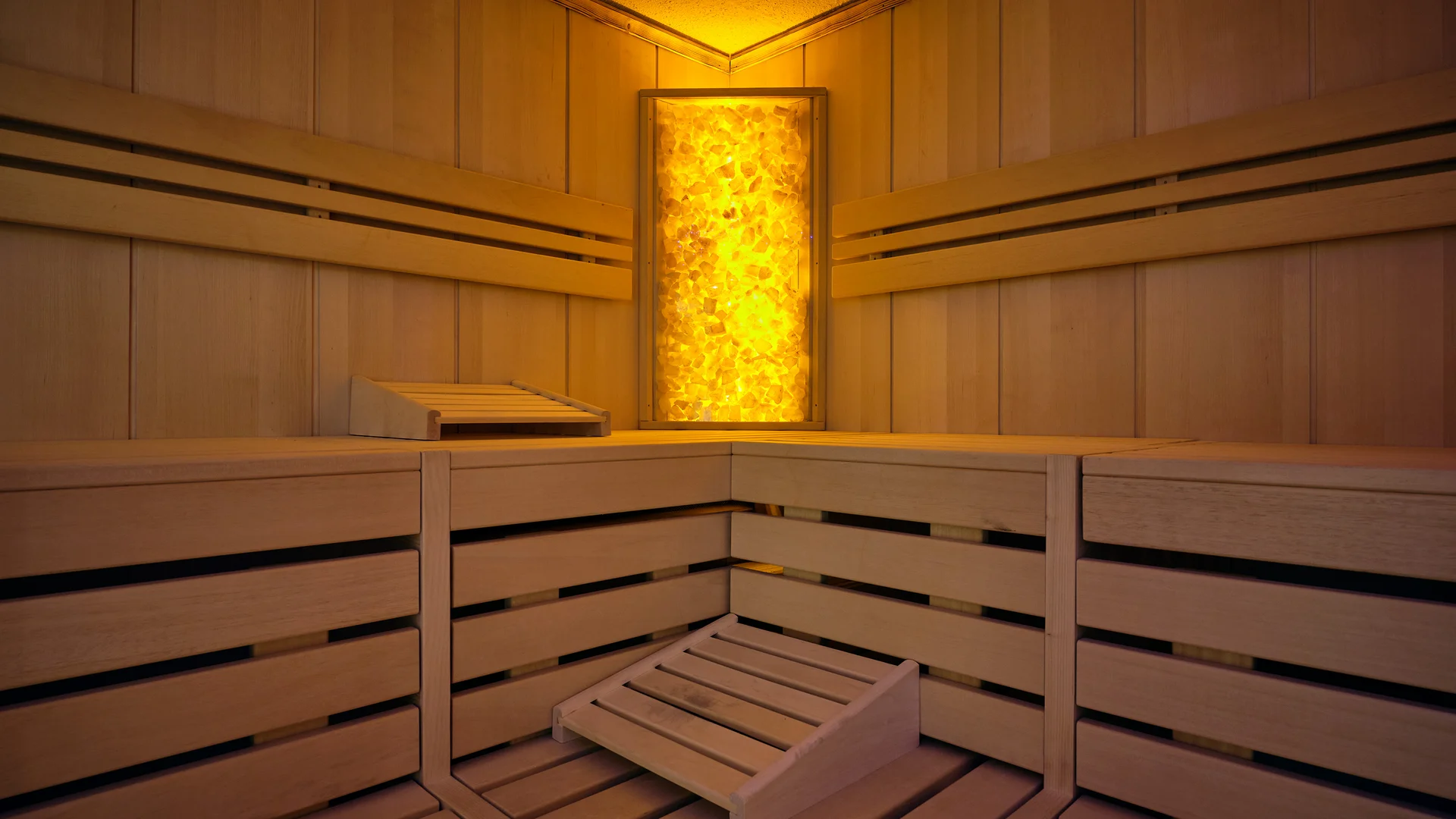 Innenraum einer Sauna mit Holzverkleidung und warmem Licht