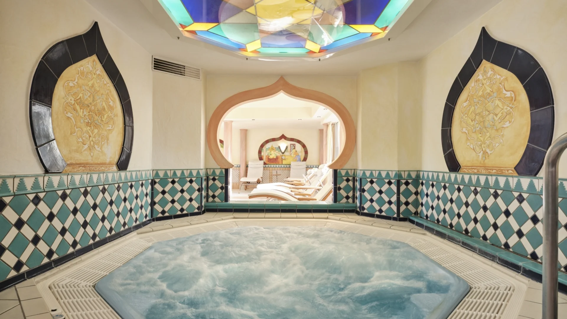 Whirlpool mit buntem Glasdach und orientalischer Wanddekoration